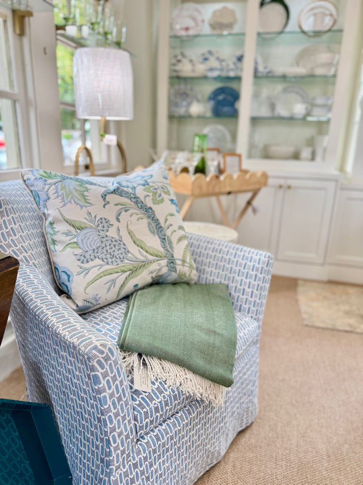 Custom blue patterned armchair with a green throw and decorative designer pillow